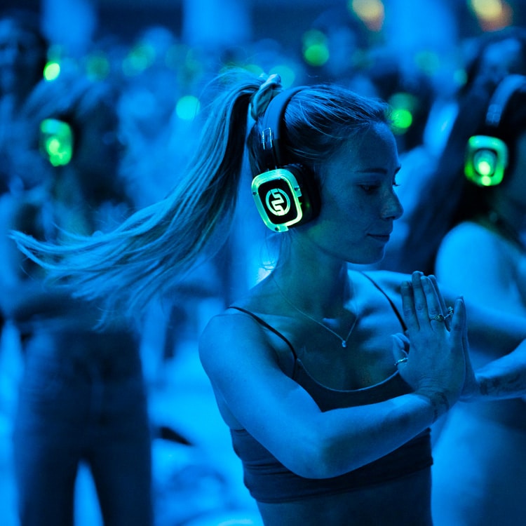 Silent yoga party with glowing headphones and blue lights